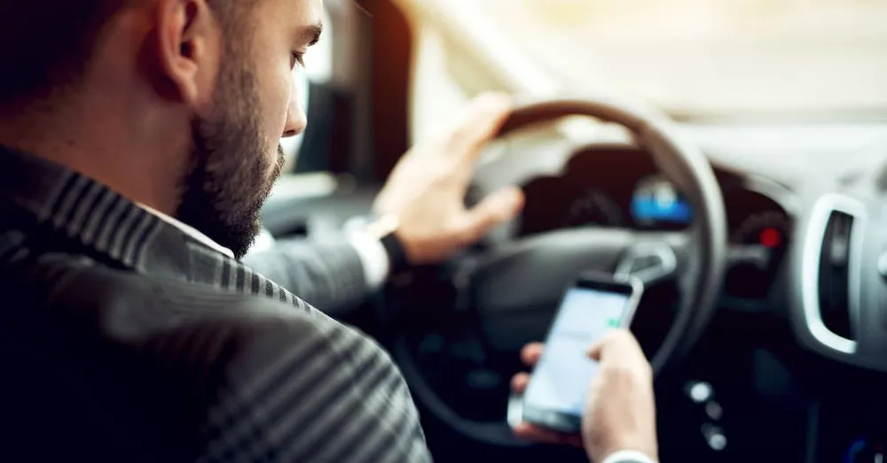 A man is using a phone while driving